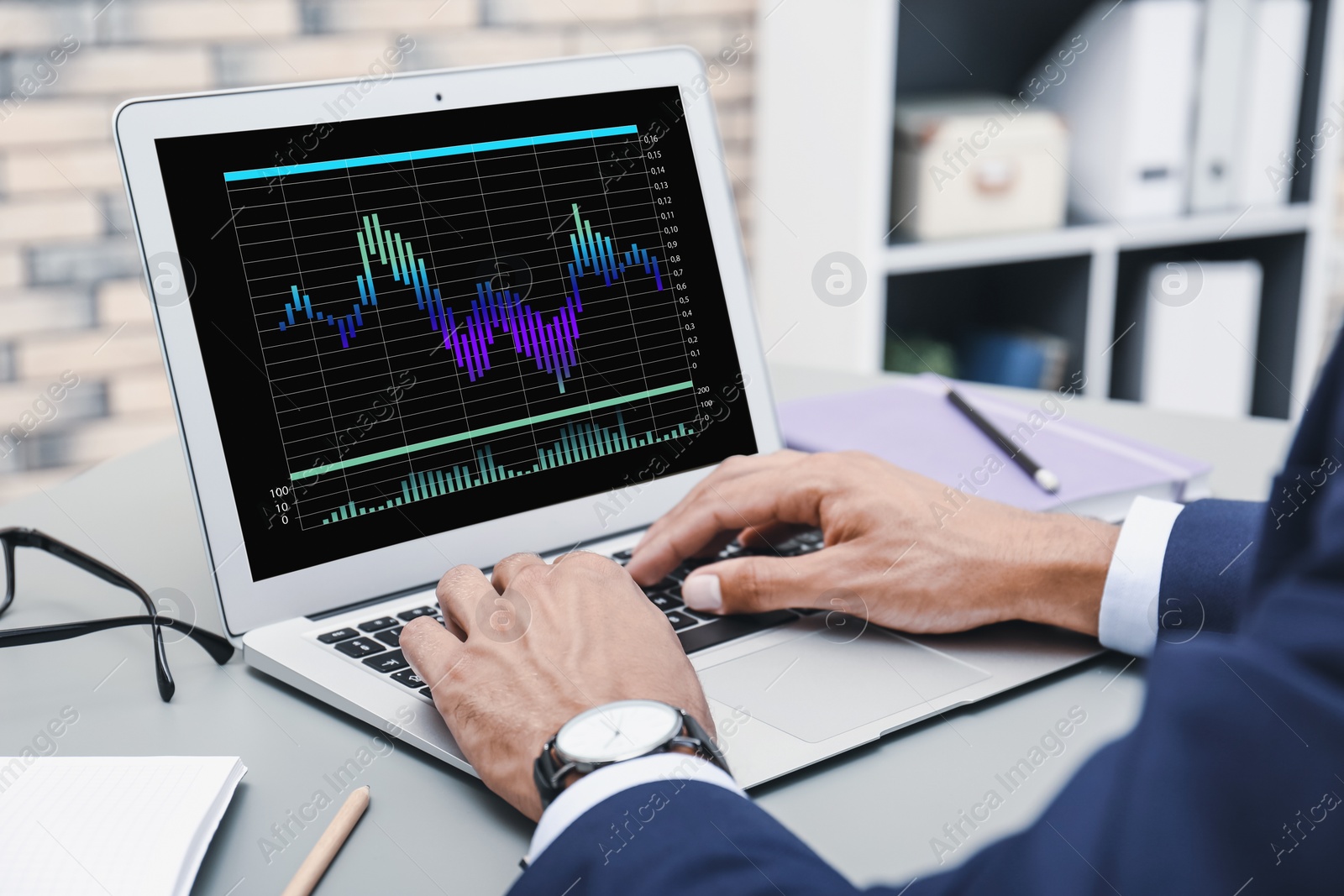 Image of  Broker working with laptop at table, closeup. Forex trading