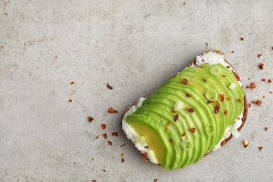 Photo of Crisp rye toast with sliced avocado and cream cheese on table, top view