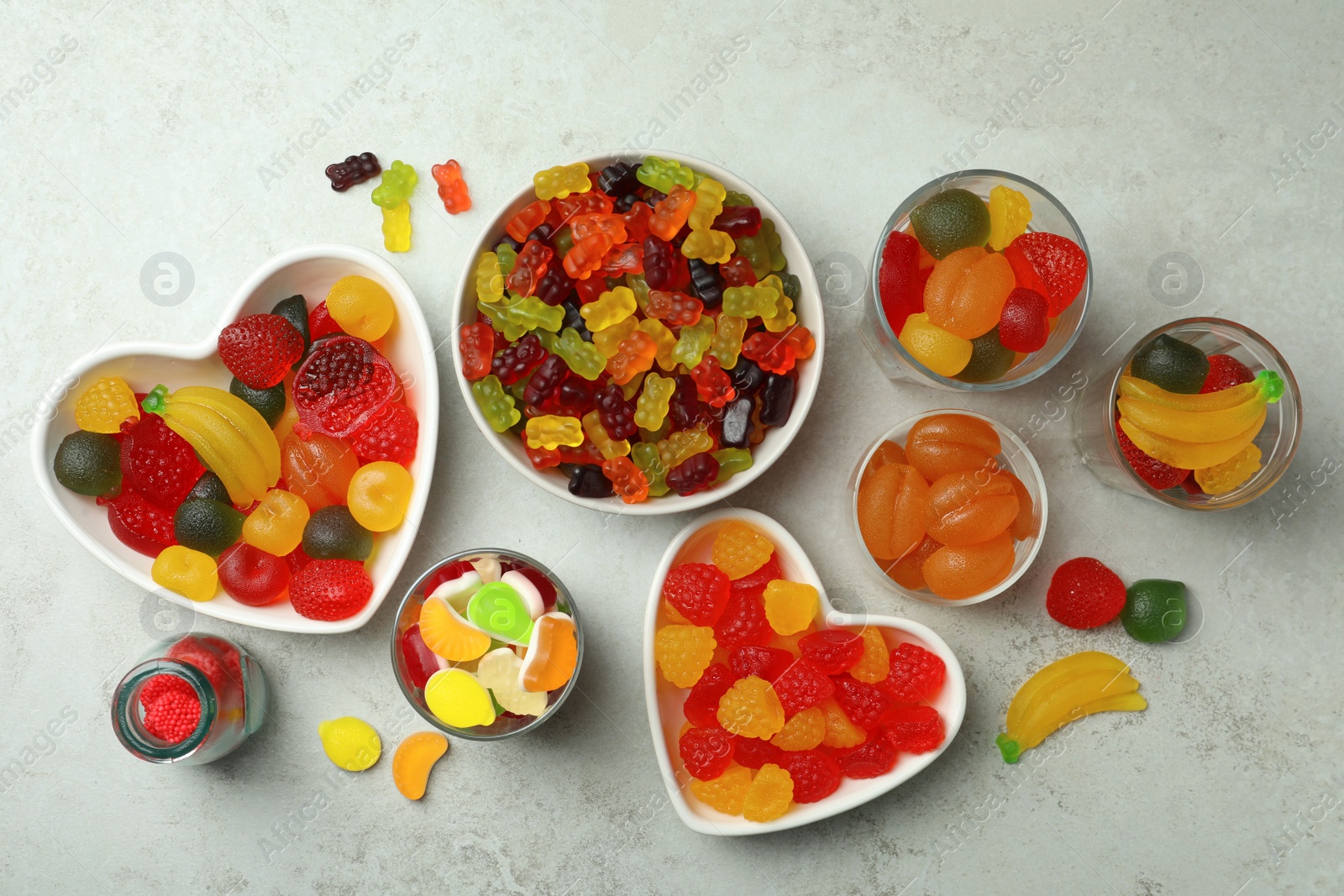 Photo of Delicious gummy candies on light grey table, flat lay