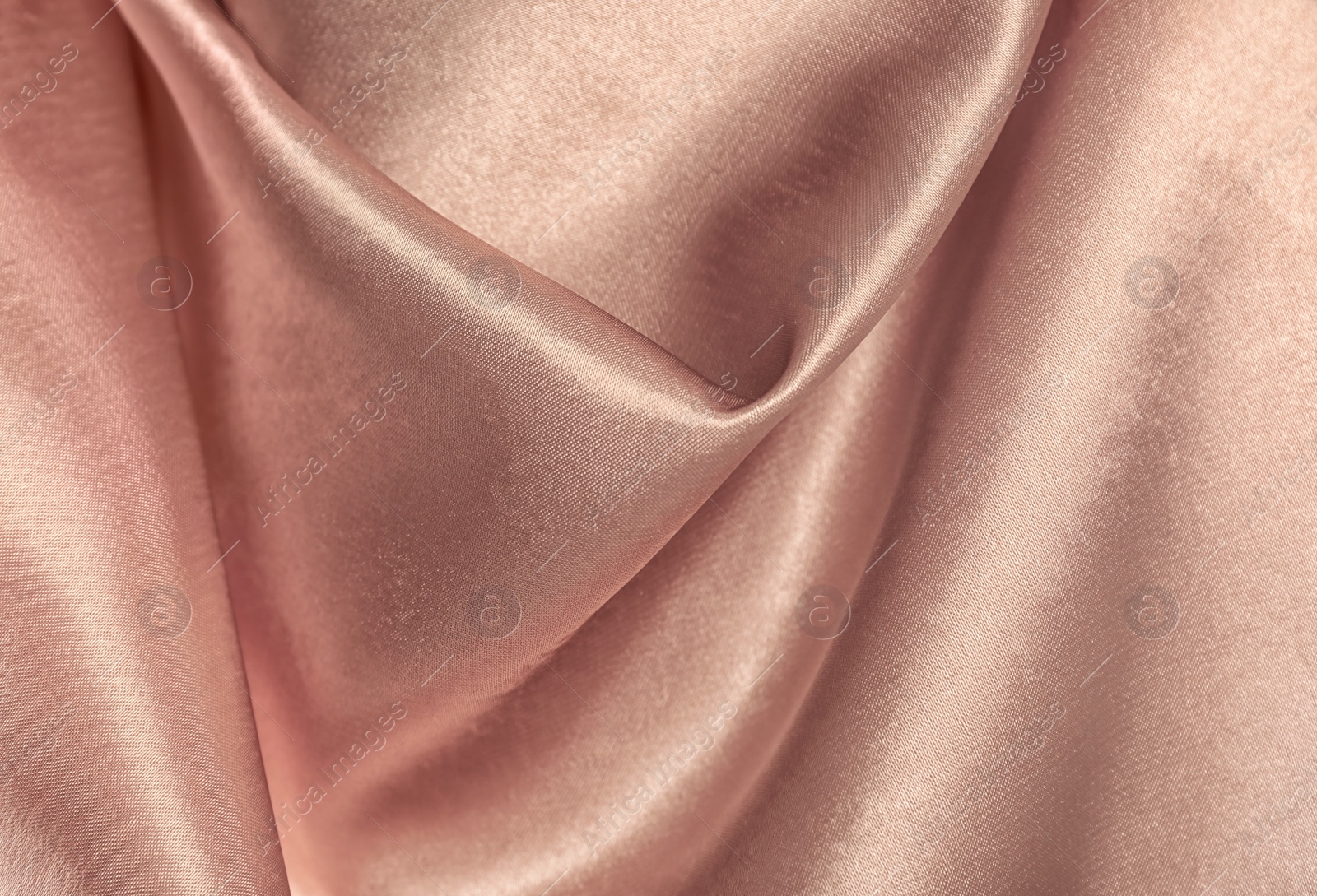 Photo of Texture of rose gold silk as background, closeup