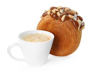 Photo of Round croissant with chocolate paste, nuts and cup of coffee isolated on white. Tasty puff pastry