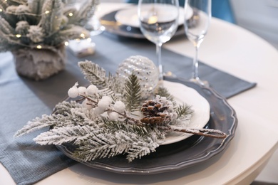 Photo of Table with set of dishware and beautiful Christmas decor in kitchen. Interior design