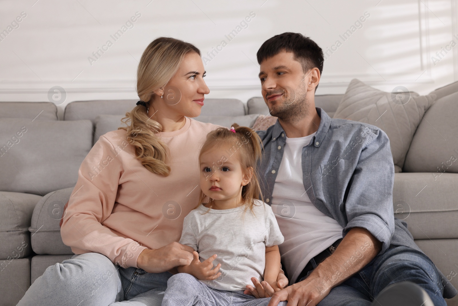 Photo of Family with little daughter spending time together at home