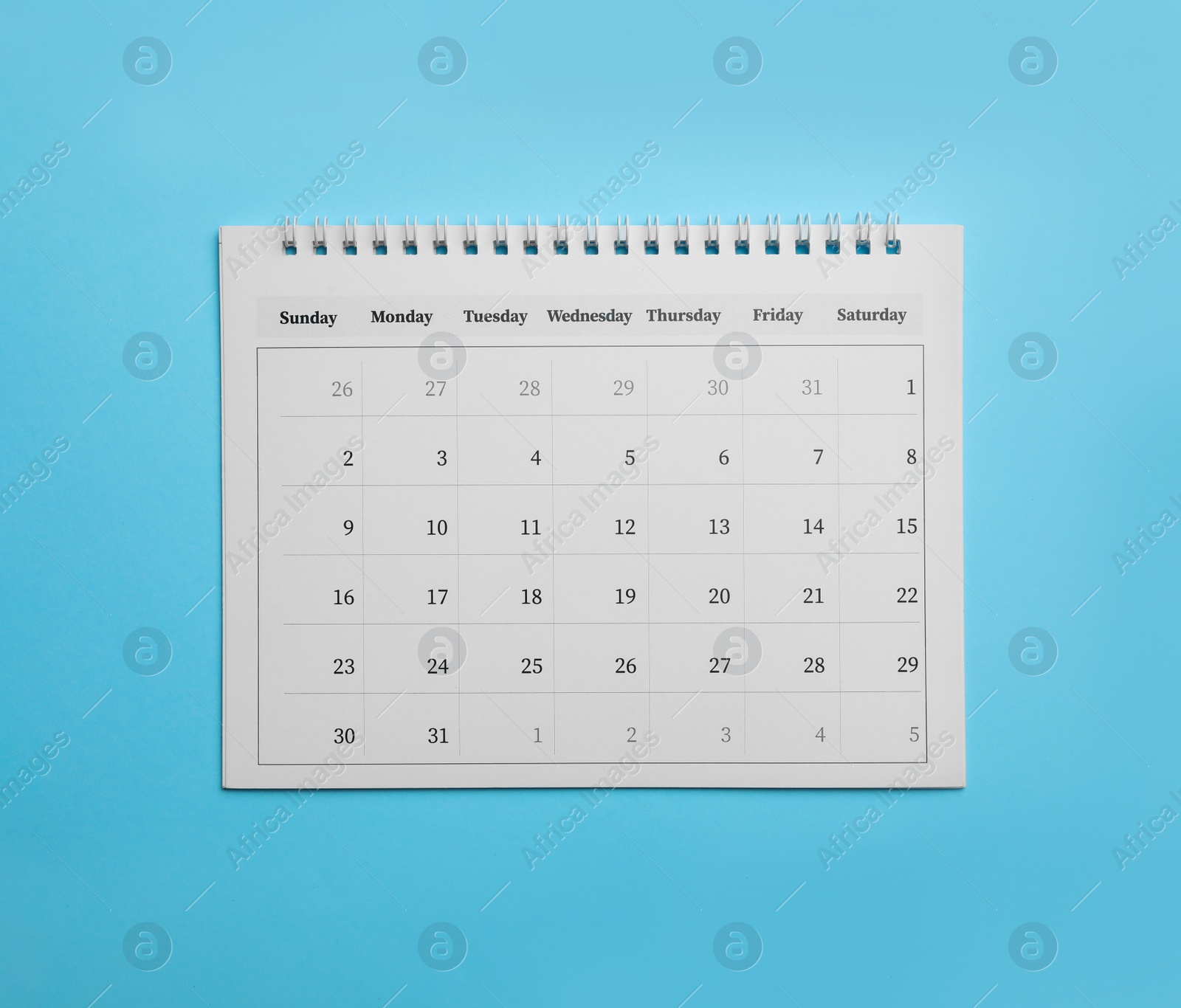 Photo of Paper calendar on light blue background, top view