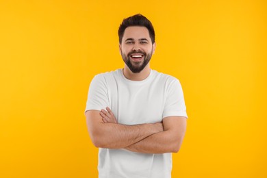 Photo of Handsome young man laughing on yellow background