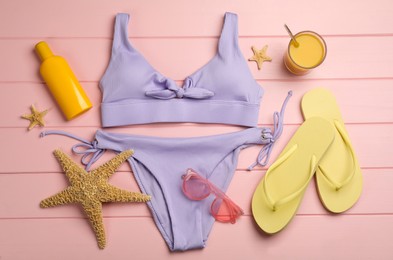 Photo of Flat lay composition with beach objects on pink wooden background