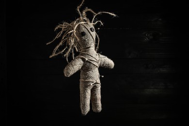 Female voodoo doll with pins on dark background