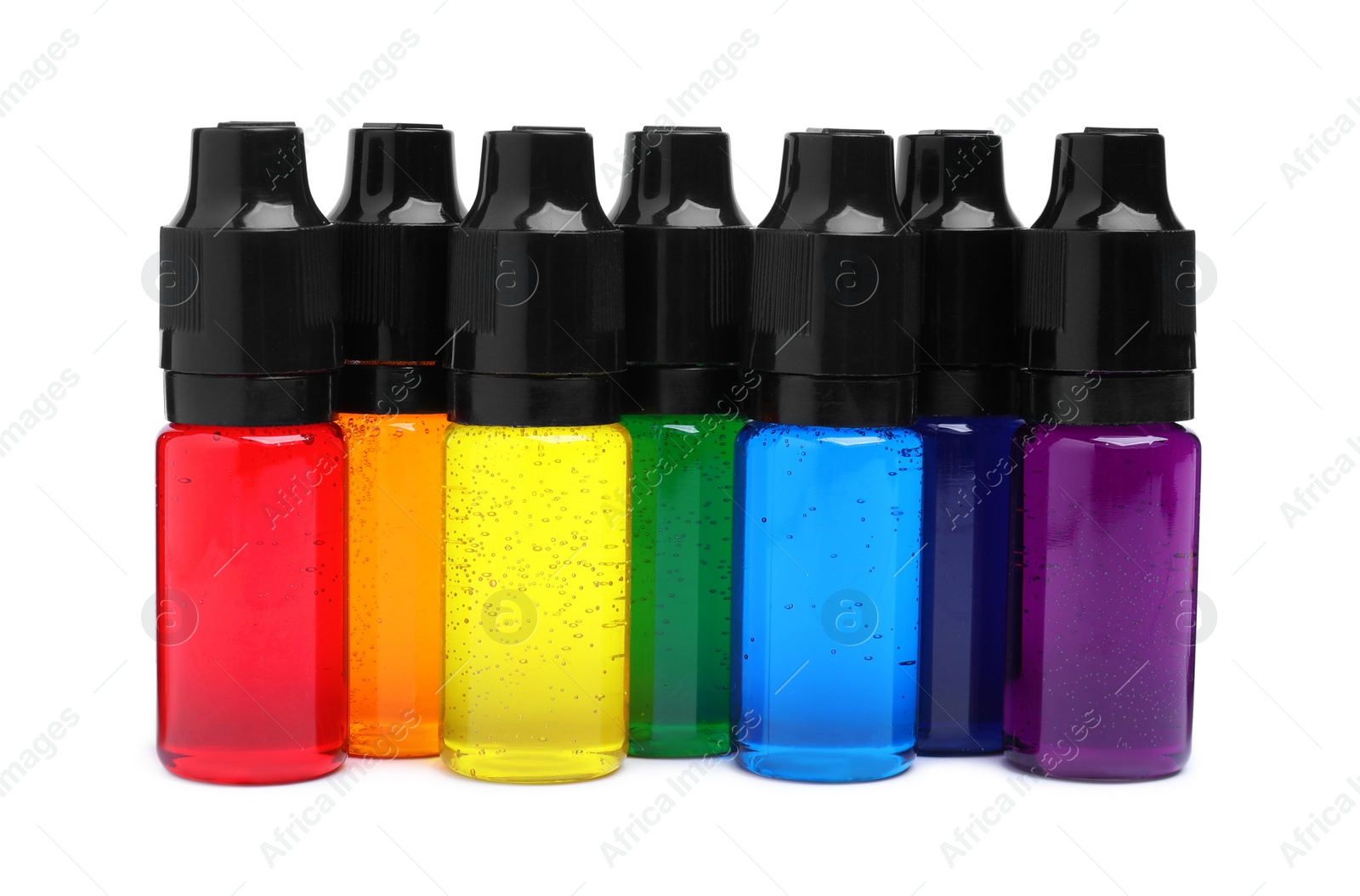 Photo of Bottles with different food coloring on white background