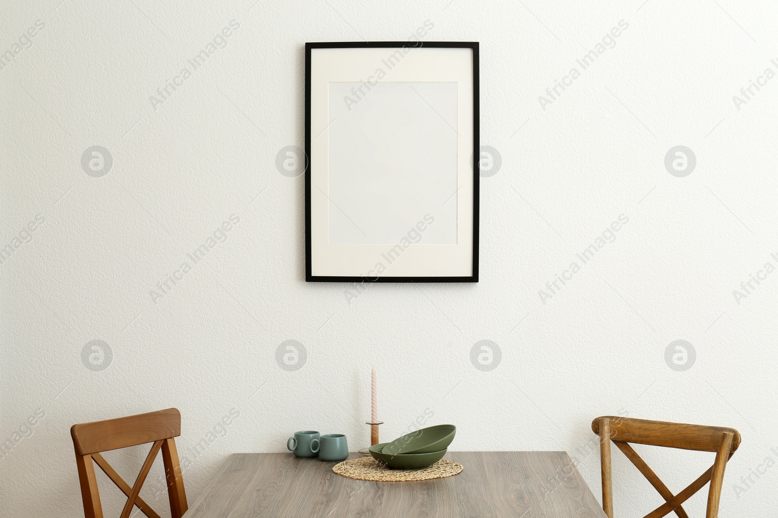 Photo of Room interior with dining table, wooden chairs and photo frame