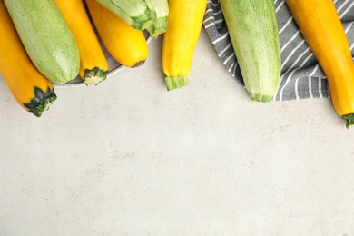 Photo of Flat lay composition with fresh ripe zucchinis on light table, space for text