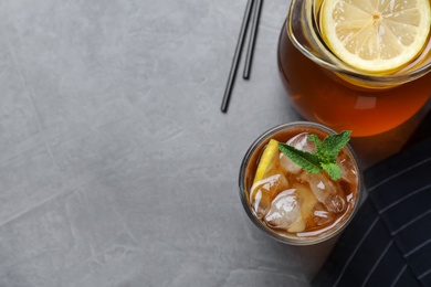 Photo of Delicious iced tea on grey table, flat lay. Space for text