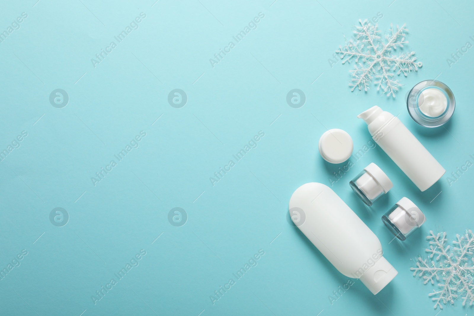 Photo of Set of cosmetic products on blue background, flat lay with space for text. Winter care