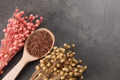 Photo of Dry flax plants and seeds on grey table, flat lay. Space for text