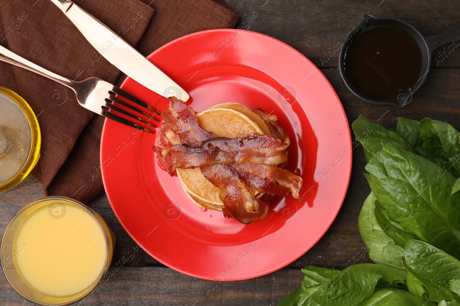 Photo of Delicious pancakes with bacon served on wooden table, flat lay