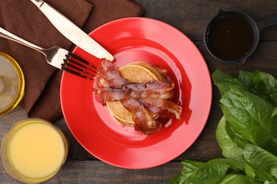 Delicious pancakes with bacon served on wooden table, flat lay