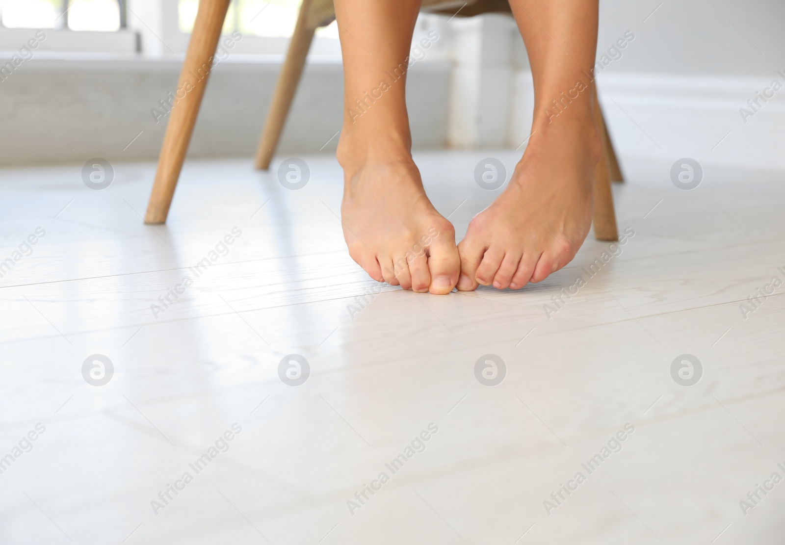 Photo of Woman suffering from foot pain at home, closeup. Space for text