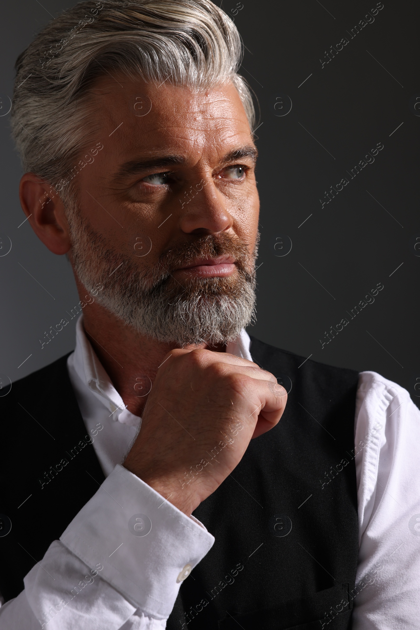 Photo of Portraitconfident man with beautiful hairstyle on dark background