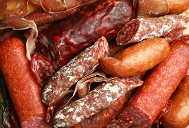 Photo of Different types of sausages as background, top view