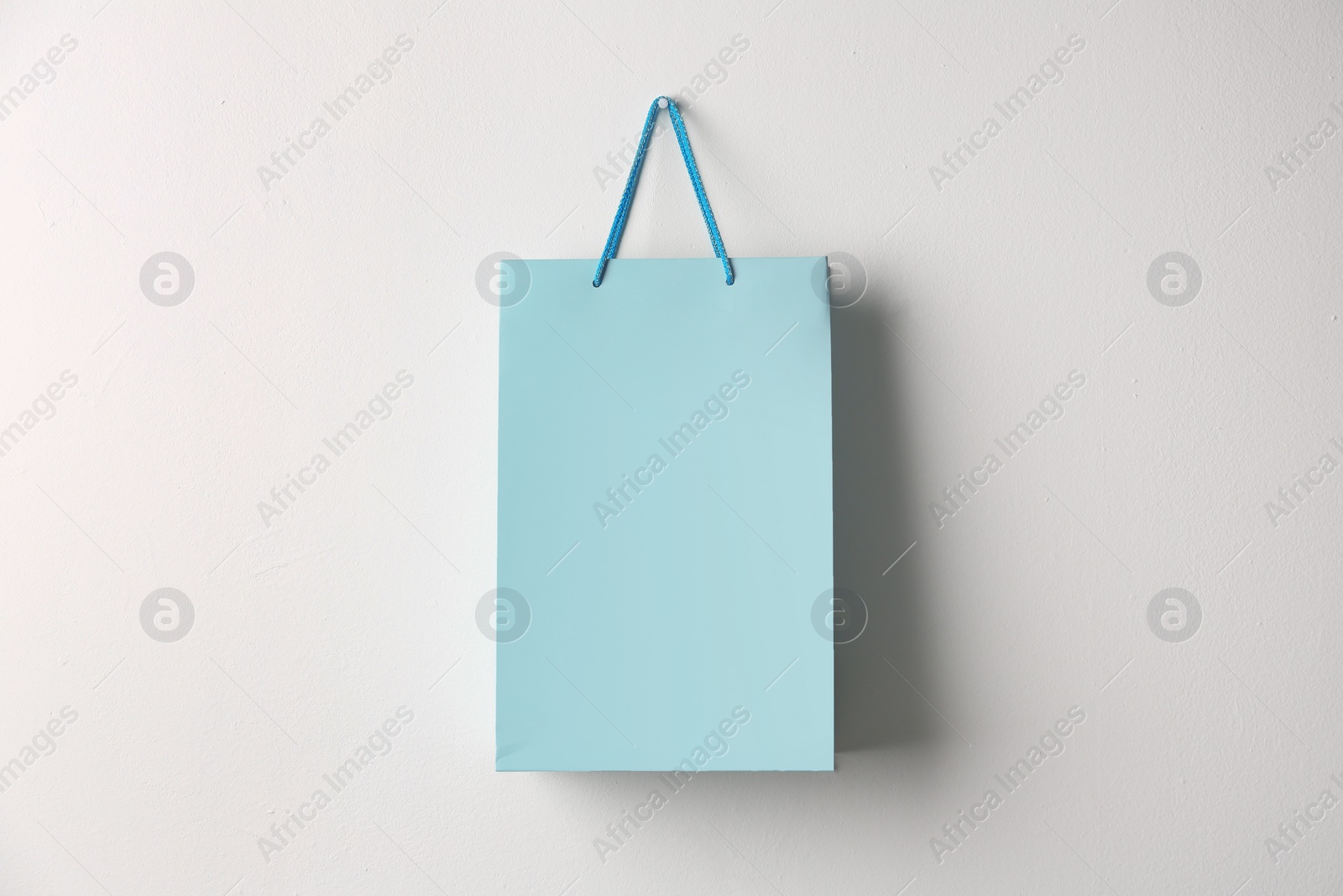 Photo of Paper shopping bag hanging on white wall