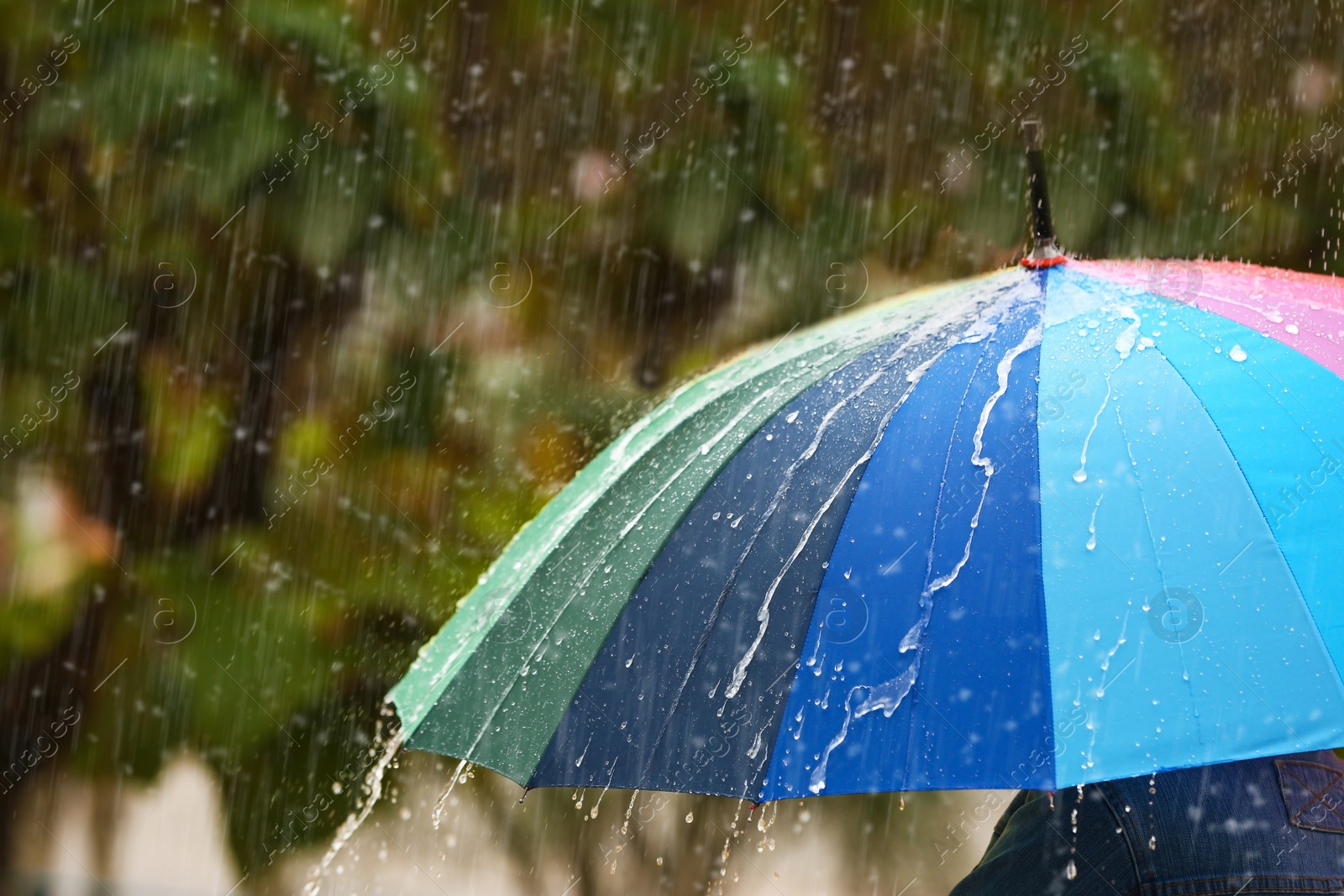 Photo of Person with bright umbrella under rain on street, closeup