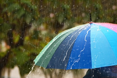 Photo of Person with bright umbrella under rain on street, closeup