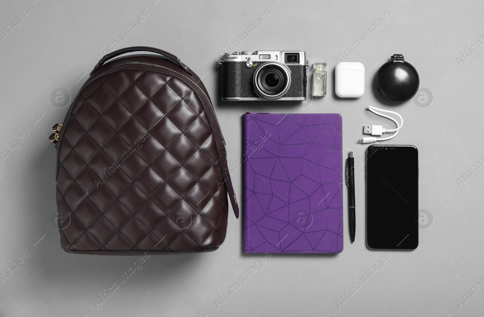 Photo of Stylish urban backpack with different items on grey background, flat lay