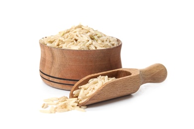 Bowl and scoop with raw unpolished rice on white background