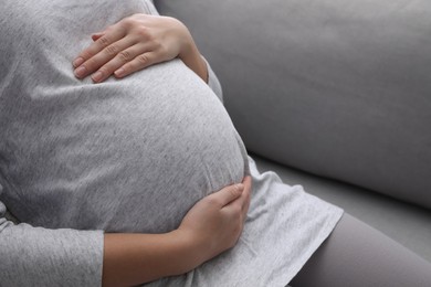 Photo of Pregnant woman resting on sofa, closeup view