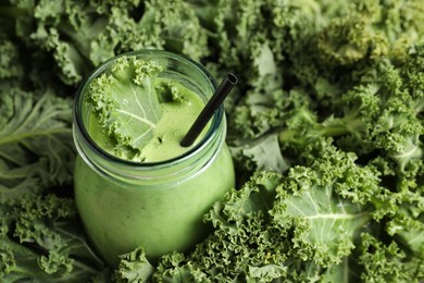 Tasty fresh kale smoothie in green leaves, closeup