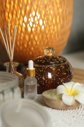 Photo of Composition with different spa products and plumeria flower on table, closeup