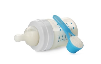 Photo of Feeding bottle with infant formula and scoop of powder on white background. Baby milk