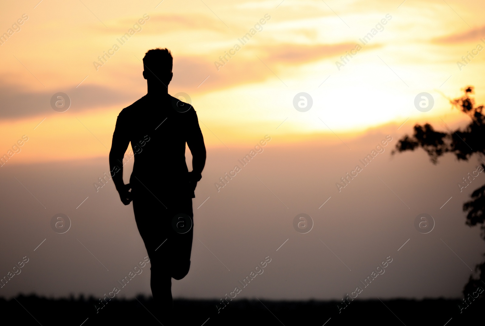 Photo of Young man running outdoors in evening. Space for text