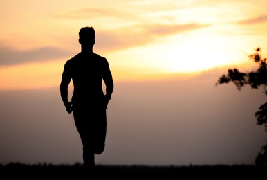 Photo of Young man running outdoors in evening. Space for text