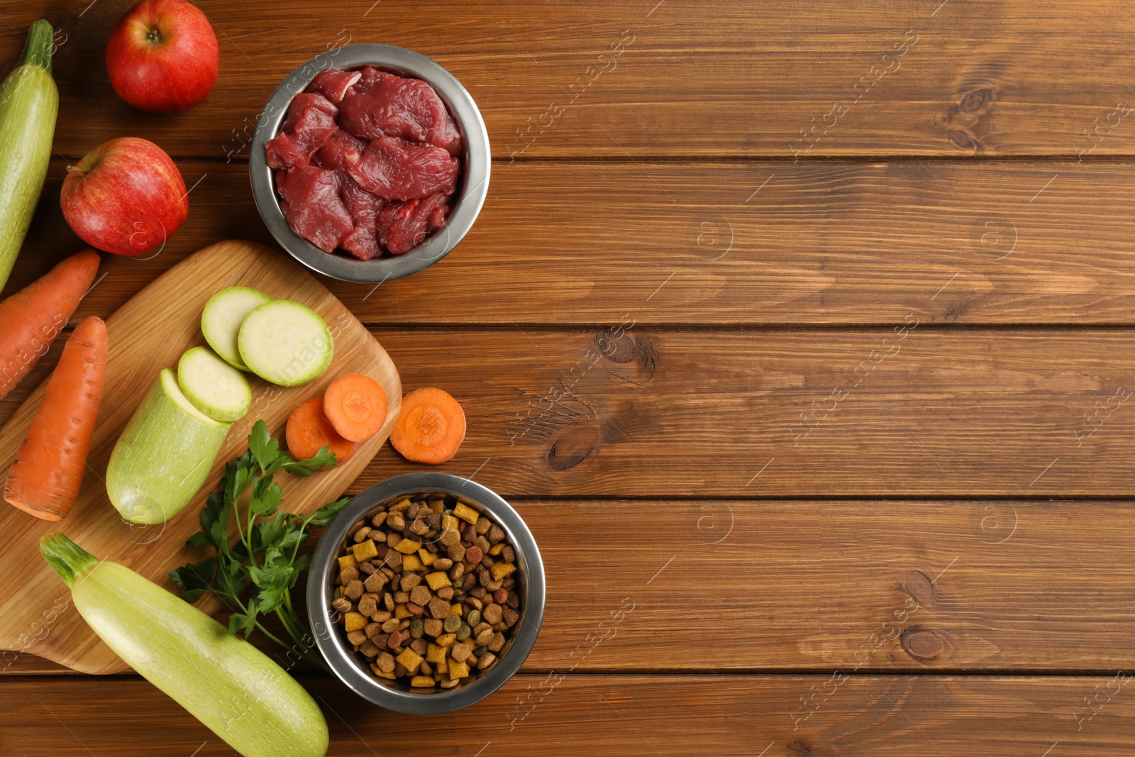 Photo of Pet food and natural ingredients on wooden table, flat lay. Space for text