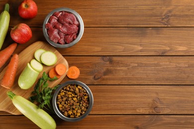 Pet food and natural ingredients on wooden table, flat lay. Space for text
