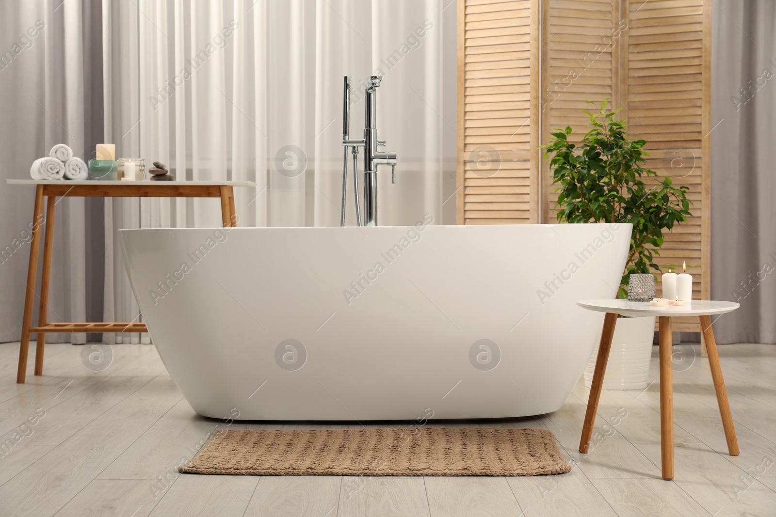 Photo of Ceramic tub, houseplant and spa products in bathroom