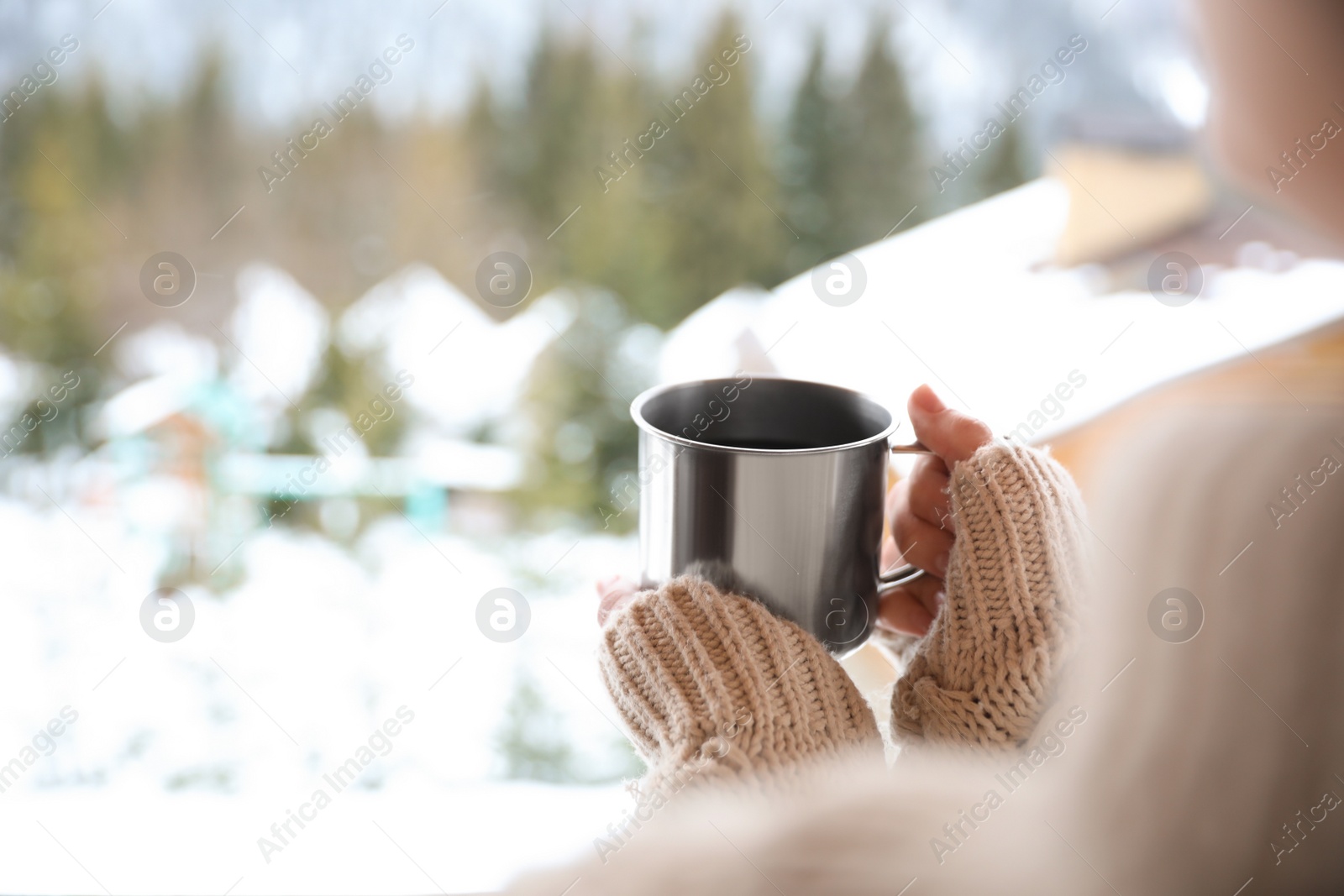 Photo of Woman with cup of tasty coffee outdoors on winter morning, closeup