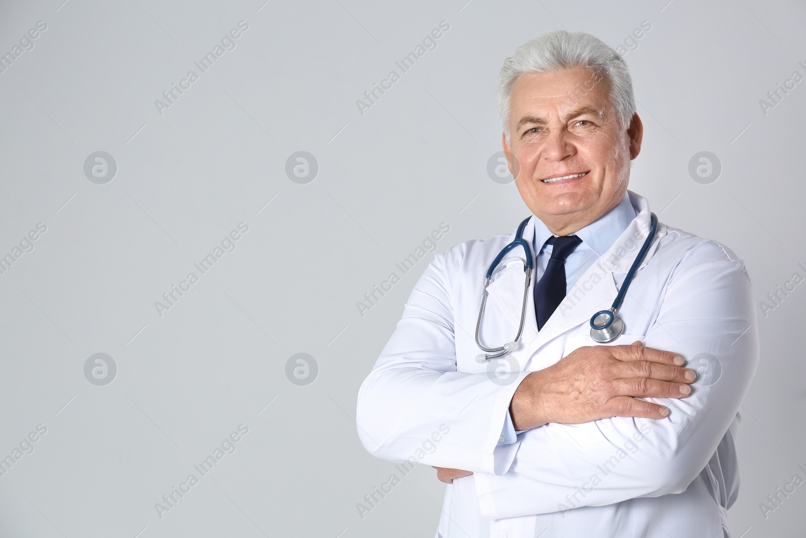 Photo of Portrait of senior doctor against light background