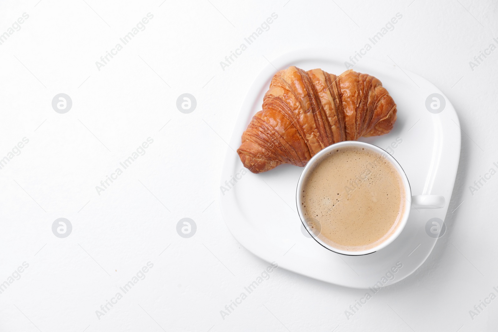 Photo of Breakfast time. Fresh croissant and coffee on white background, top view. Space for text