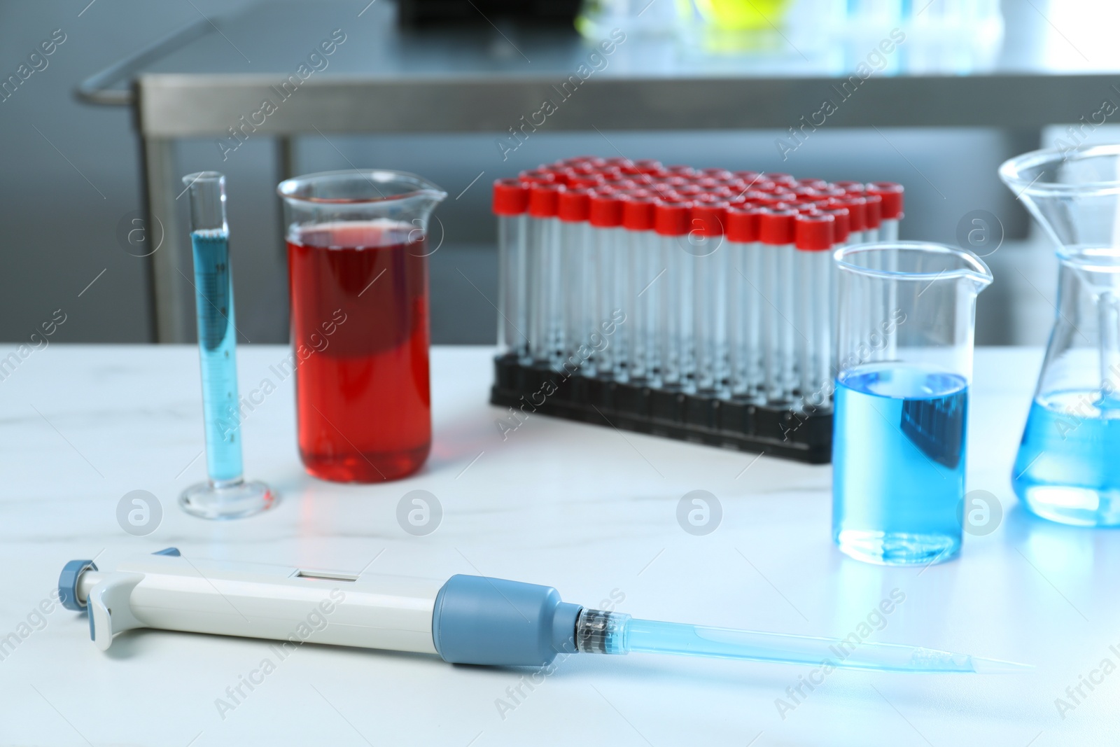 Photo of Laboratory analysis. Micropipette and different glassware on white marble table