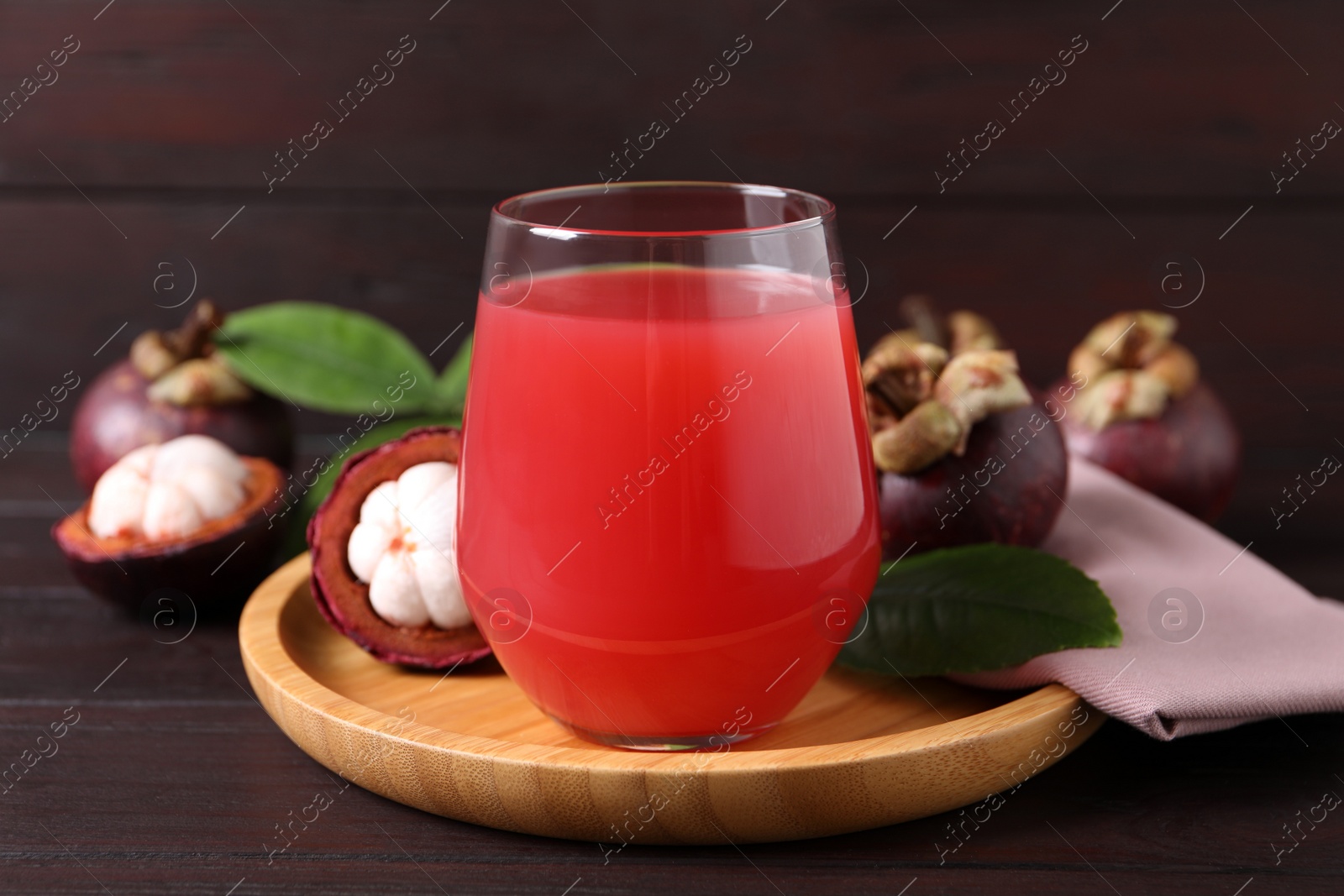 Photo of Delicious mangosteen juice in glass on wooden table