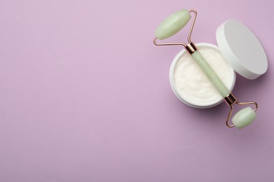 Natural face roller and cosmetic product on pink background, top view. Space for text