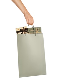 Photo of Woman holding paper shopping bag full of gift boxes on white background, closeup