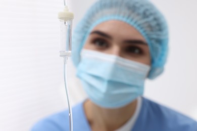 Photo of Setting up IV drip. Nurse on blurred background, selective focus