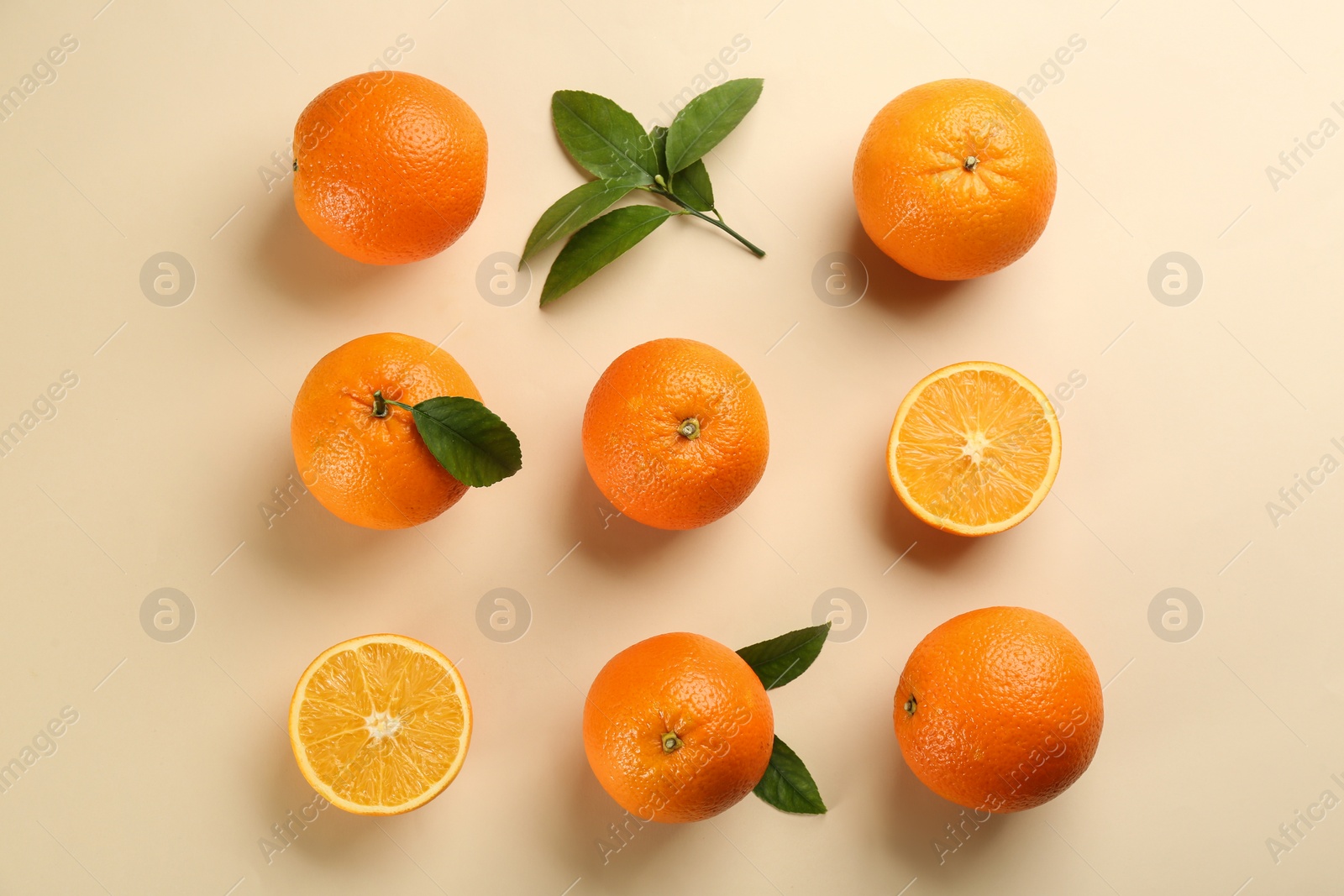 Photo of Delicious oranges on beige background, flat lay
