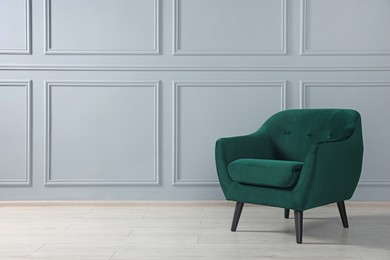 Photo of Comfortable armchair near light grey wall indoors. Space for text