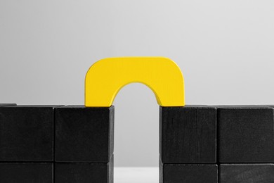 Photo of Bridge made of blocks on grey background, closeup. Connection, relationships and deal concept