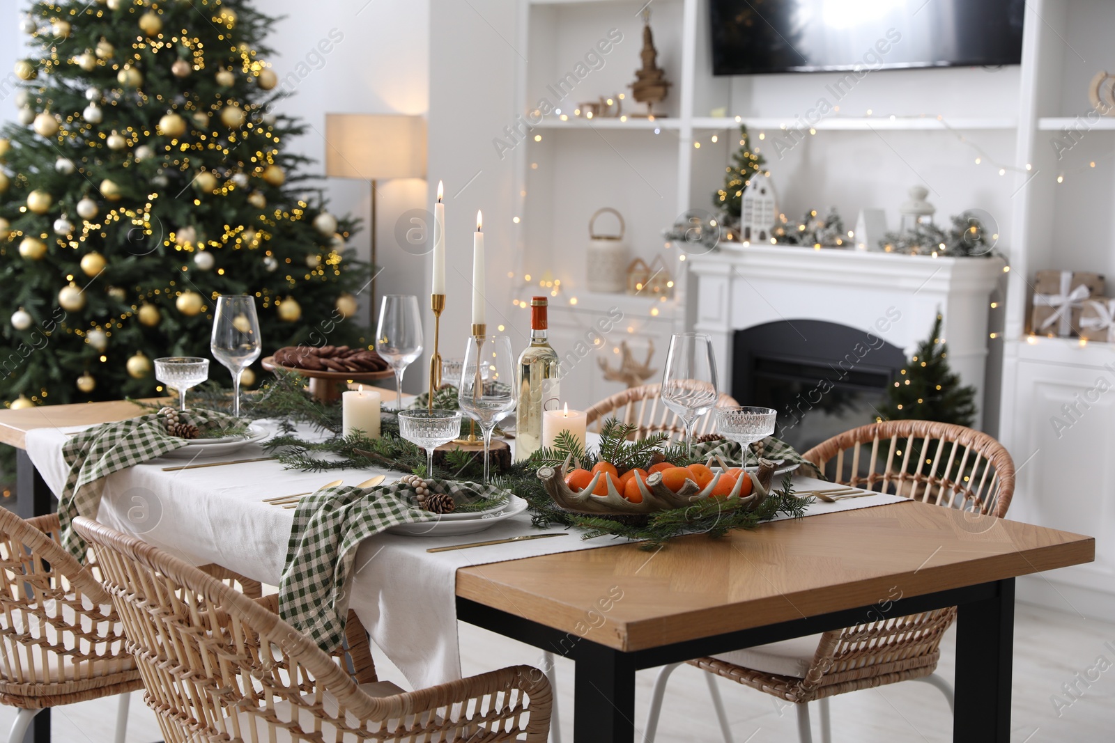 Photo of Christmas table setting with festive decor and dishware in living room