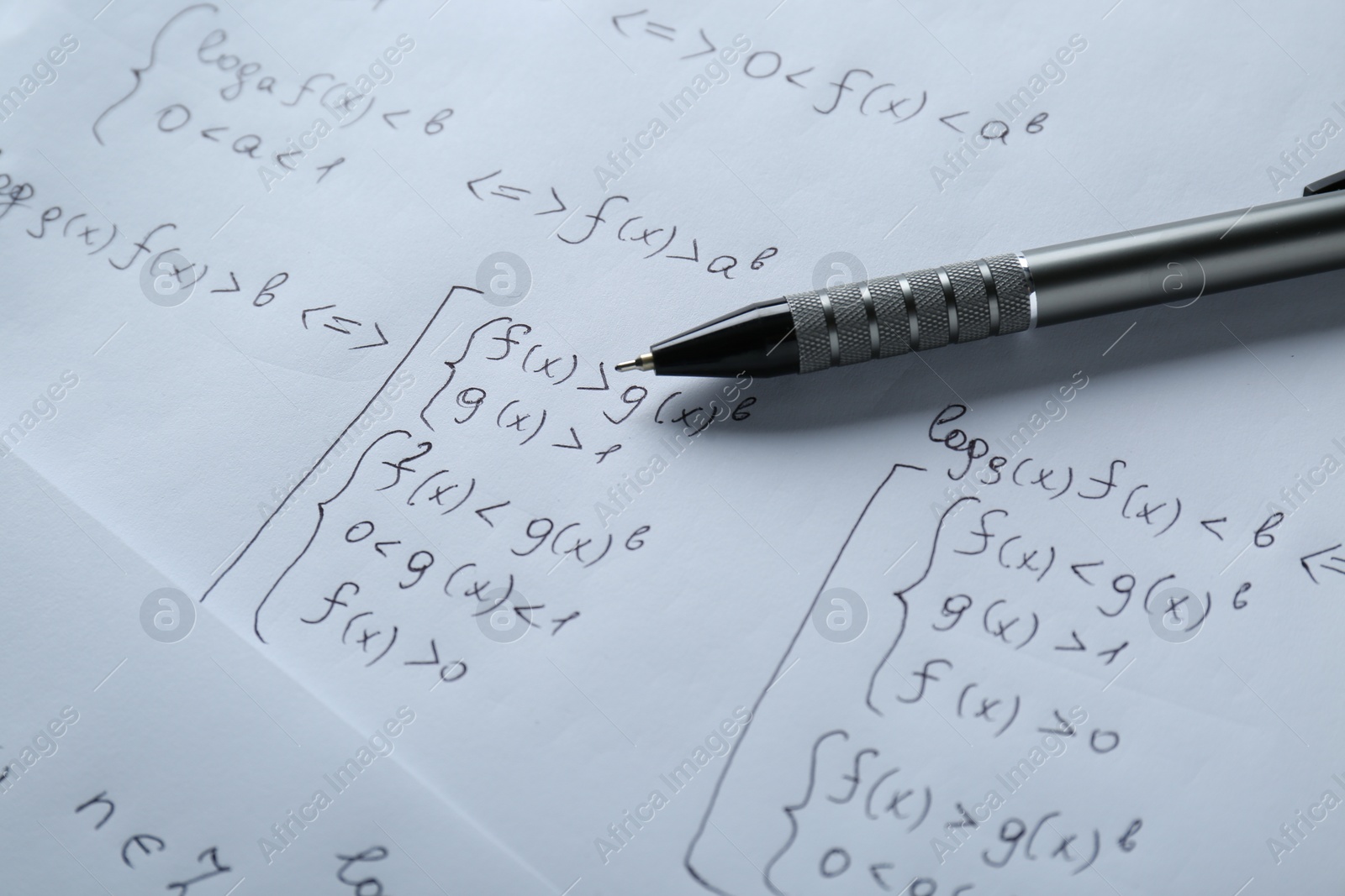 Photo of Sheets of paper with different mathematical formulas and pen, closeup