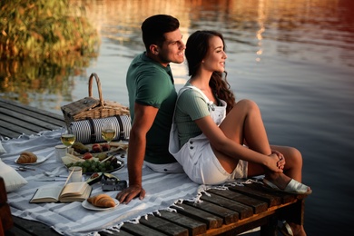 Happy couple spending time on pier at picnic